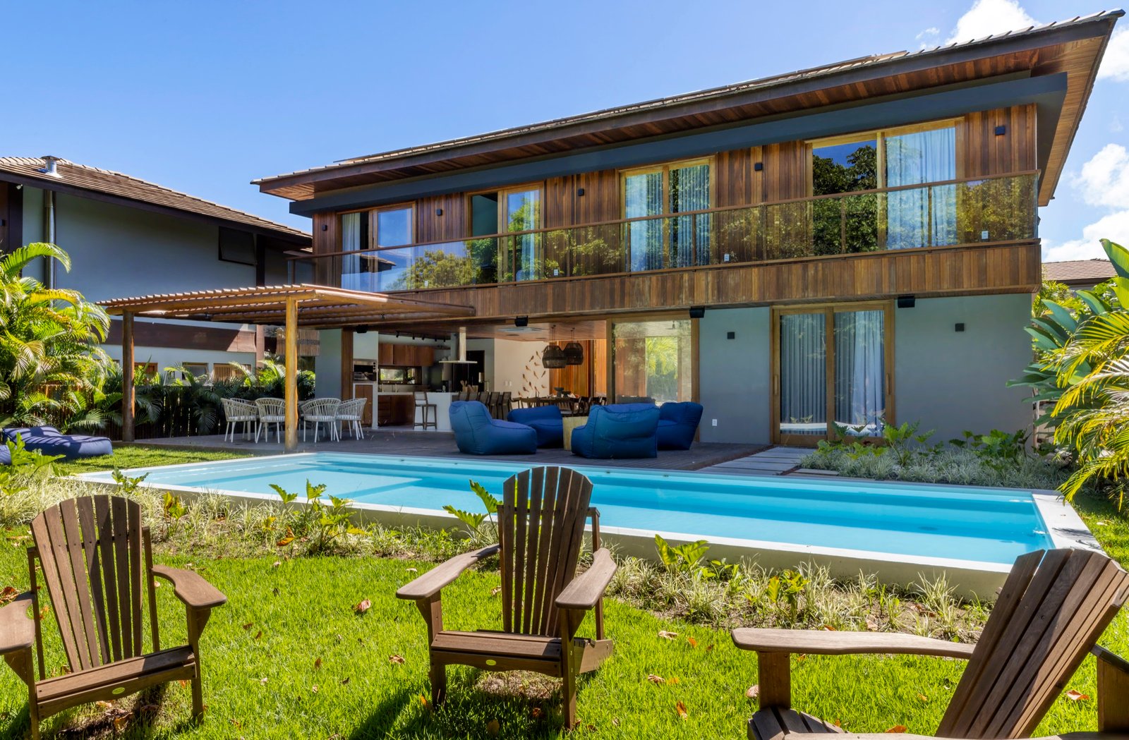 Fachada posterior da Casa Pássaros com piscina e jardim